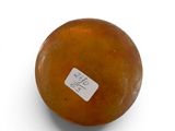 an orange with a sticker on it sitting on a white surface