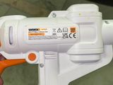 a person holding an orange and white spray gun