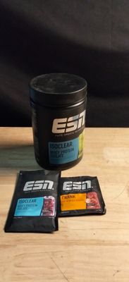 three packets of protein sitting on a table next to a cup of coffee