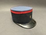 un chapeau noir orné d'un ruban rouge sur le dessus