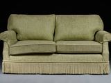 a green couch with a ruffled skirt on it