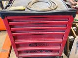 une boîte à outils rouge posée sur une table dans un garage