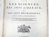un livre ouvert, dont le titre est visible, posé sur une table
