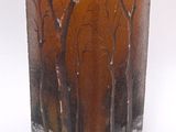 un vase en verre contenant une bougie jaune
