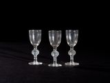 three empty wine glasses sitting on a black surface