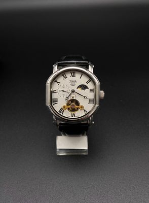 gros plan d'une montre sur une surface noire avec un fond noir