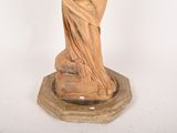 a statue of a woman holding a bird on a pedestal