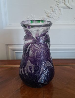 un vase violet posé sur une table en bois dans une pièce