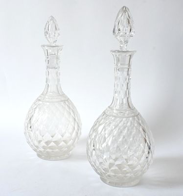 two clear glass vases sitting next to each other on a white surface