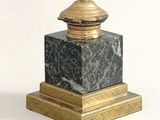 a black and gold marble pedestal with a gold lid
