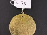 a gold medal with a white tag attached to it