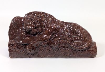 figurine en chocolat représentant un chien couché sur une surface blanche