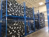 a lot of tires stacked on a rack in a warehouse