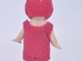 a doll that is wearing a pink dress and a hat