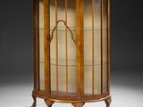 a victorian walnut display cabinet with glass shelves and a curved glass door