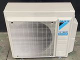 un gros plan d'un climatiseur blanc posé par terre
