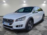 une voiture blanche garée dans une pièce au sol en damier
