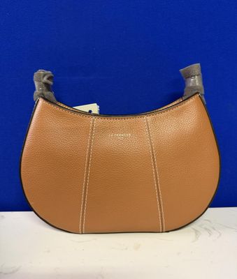 a brown leather purse with a metal handle on a white table