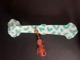 a dog bone with a tassel hanging from it ' s end