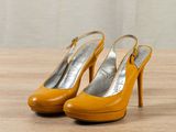 an image of a pair of yellow high heels on a wooden table