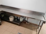 a stainless steel work table with two buckets on it