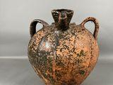 un vase marron et noir posé sur une table