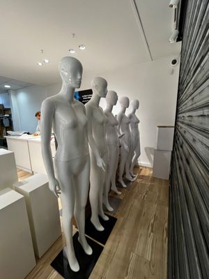 de nombreux mannequins alignés en rang dans un magasin