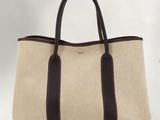 un sac fourre-tout marron et blanc posé sur une table blanche