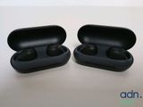 two black earphones sitting on top of a table next to each other