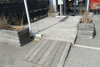 two wooden planters on the side of the street