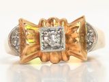 bague en or jaune et blanc, avec un diamant central entouré de deux diamants plus petits