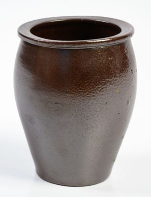 un vase brun posé sur une surface blanche