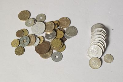 une pile de pièces de monnaie posée sur une table à côté d'une pile de pièces de monnaie