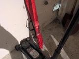 a red umbrella sitting on the floor next to a floor jack