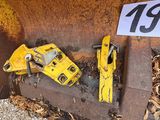 two yellow construction tools on the ground next to a number plate