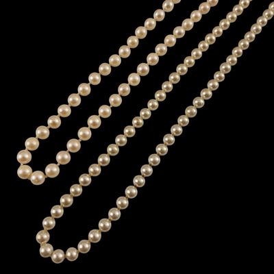 un gros plan d'un collier de perles sur fond noir