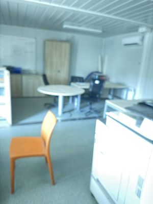 a blurry image of a kitchen with a table and a chair