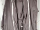 grey pants hanging on a hanger on a white wall