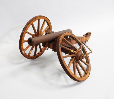 an old wooden cannon sitting on top of a white surface