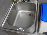 a stainless steel sink with a blue trash can next to it