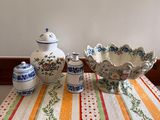 a table with a bowl, vases, and salt shakers on it