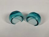 pair of blue glass ear plugs on a white surface