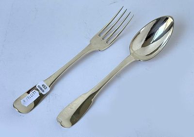 two forks and a spoon on a white table