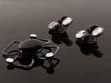 two black and white cufflinks sitting on top of a black surface