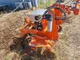 an orange machine that is sitting in the grass