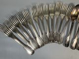 a lot of silver spoons and forks arranged in a circle