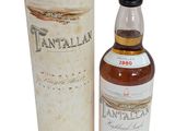 a bottle of tantalan whisky next to a cardboard box