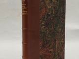 un vieux livre à la couverture marron ornée d'un motif floral