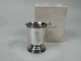 a silver cup sitting next to a box on a table