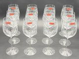 six clear wine glasses are lined up in a row on a table